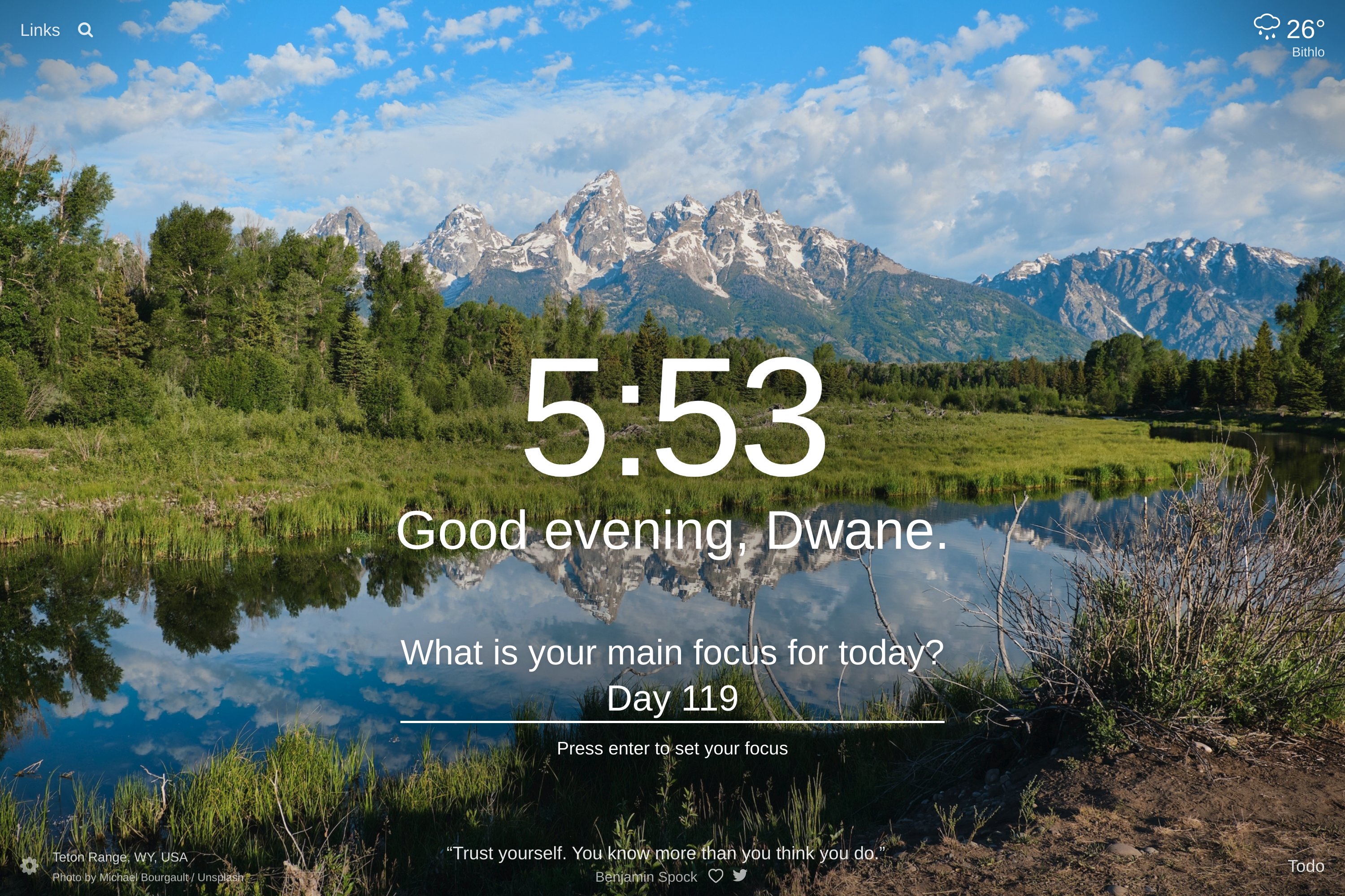 A lake surrounded by grass, forest and mountains in the background in Teton Range, Wyoming