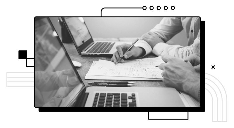 Photo showing two laptops with a person taking notes