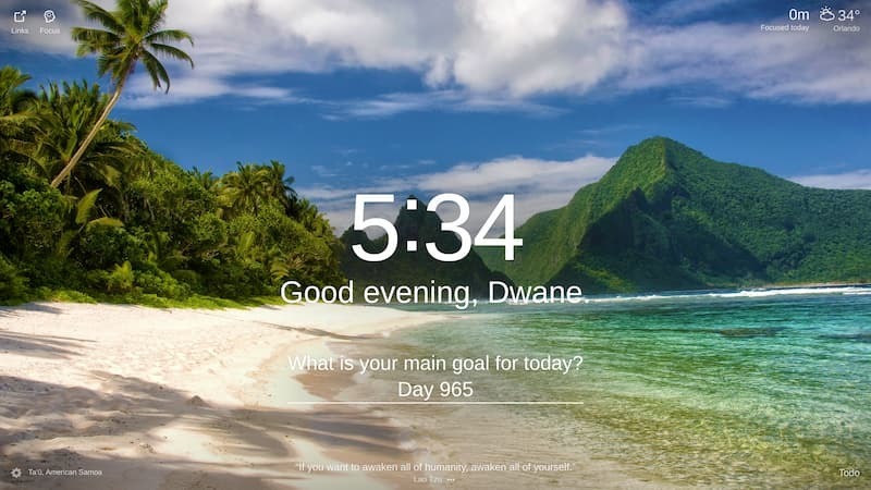  A photo of a beach in Ta‘ū, American Samoa. The beach has white sand and green palm trees. The water is a clear blue and there are green mountains in the background.