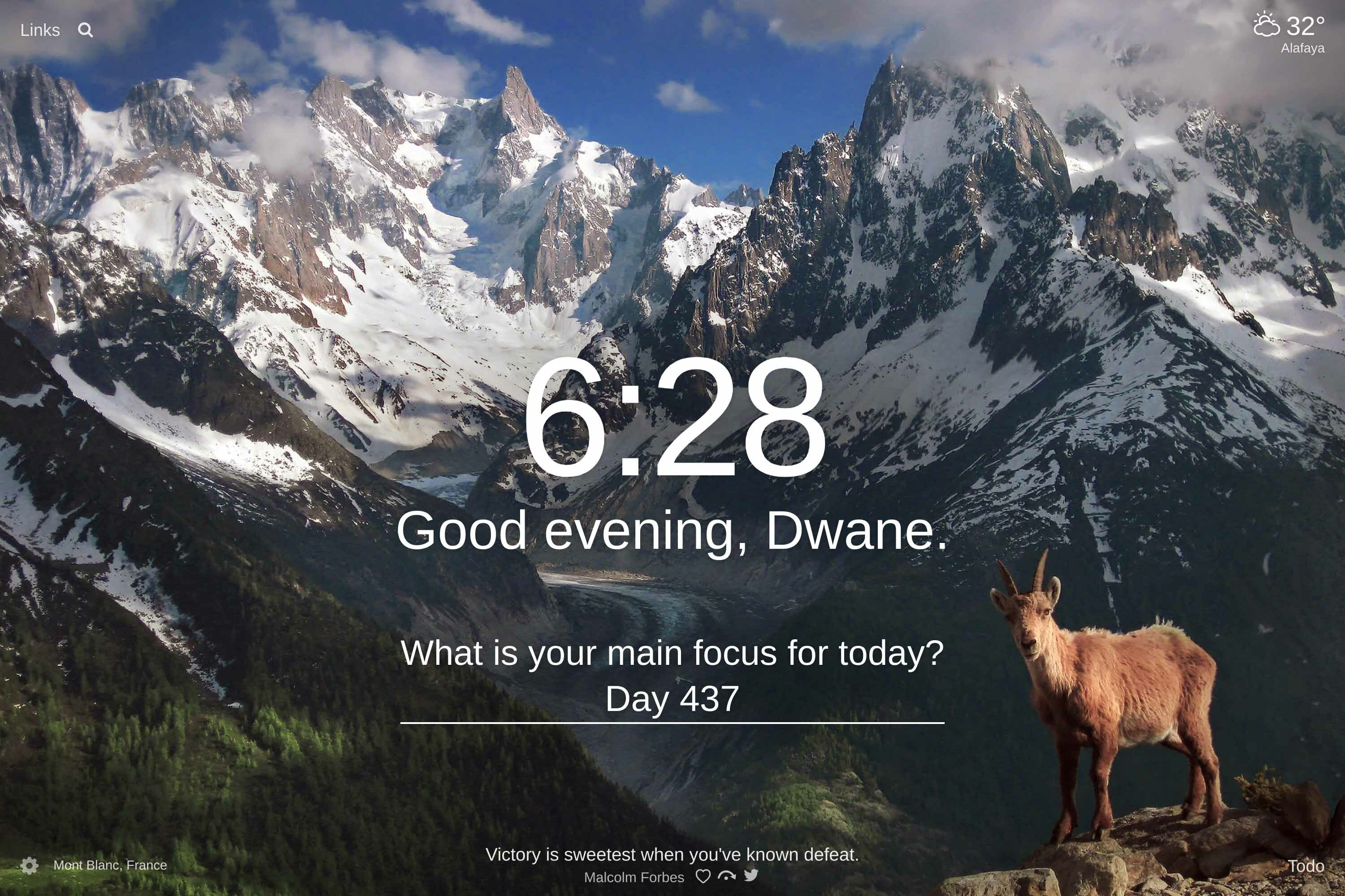 View of the snow covered mountains of Mont Blanc, France with a mountain goat in the forefront looking at the camera
