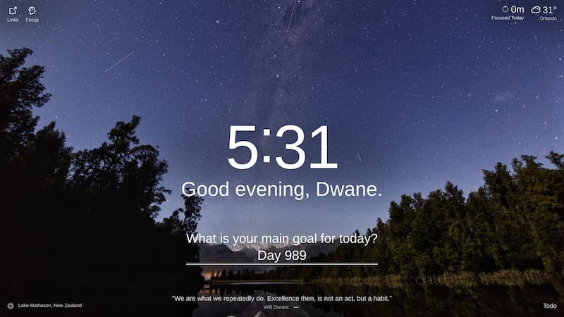 A nighttime image of a dark forest with a silhouetted mountain range and starry sky. The trees have tall dark trunks and a few dark green leaves. The Milky Way galaxy is prominent in the night sky with several shooting stars streaking across it. The ground is a dark green. Location: Lake Matheson, New Zealand.