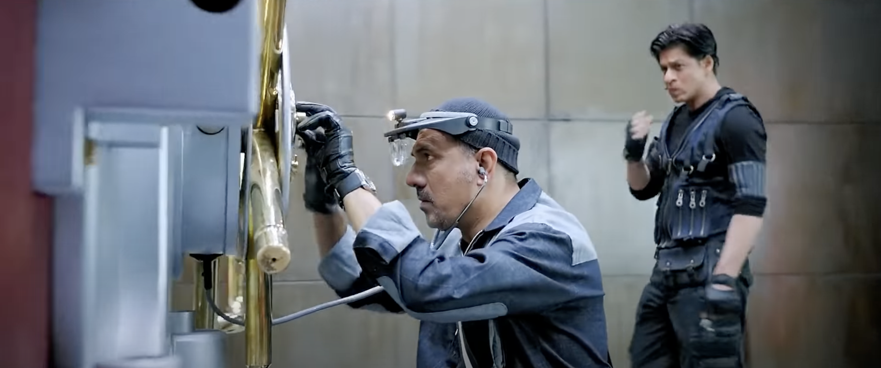 A scene from Bollywood movie Happy New Year, Boman Irani attempting to crack a rotary combination lock of the vault