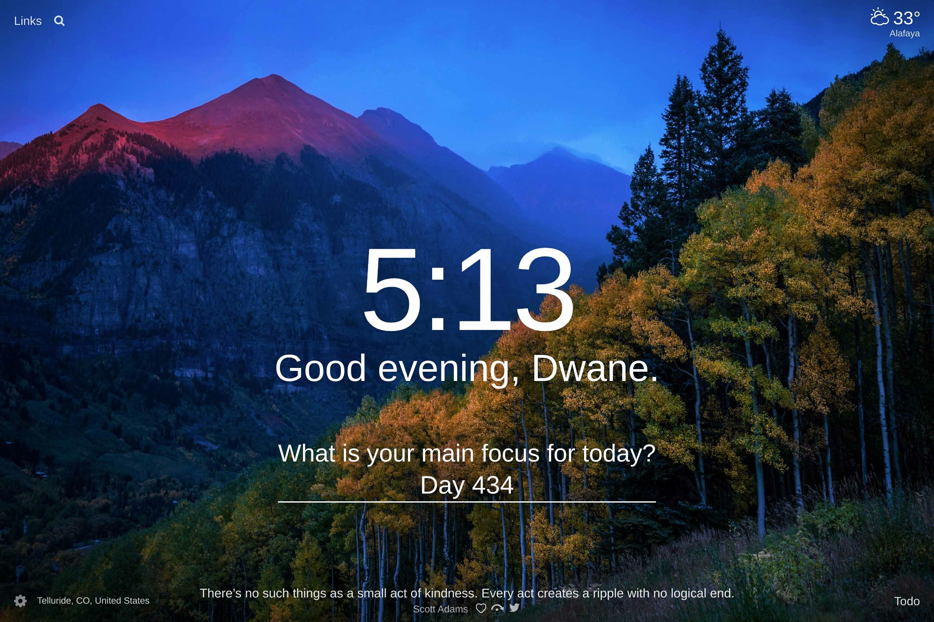 Landscape of Telluride, CO, United States at sunset with mountains in the background and a forest with orange and green leaves on the side of a mountain in the foreground.