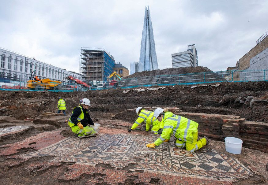 A group of archeologist excavating roman musec in London with the Shard building in the background