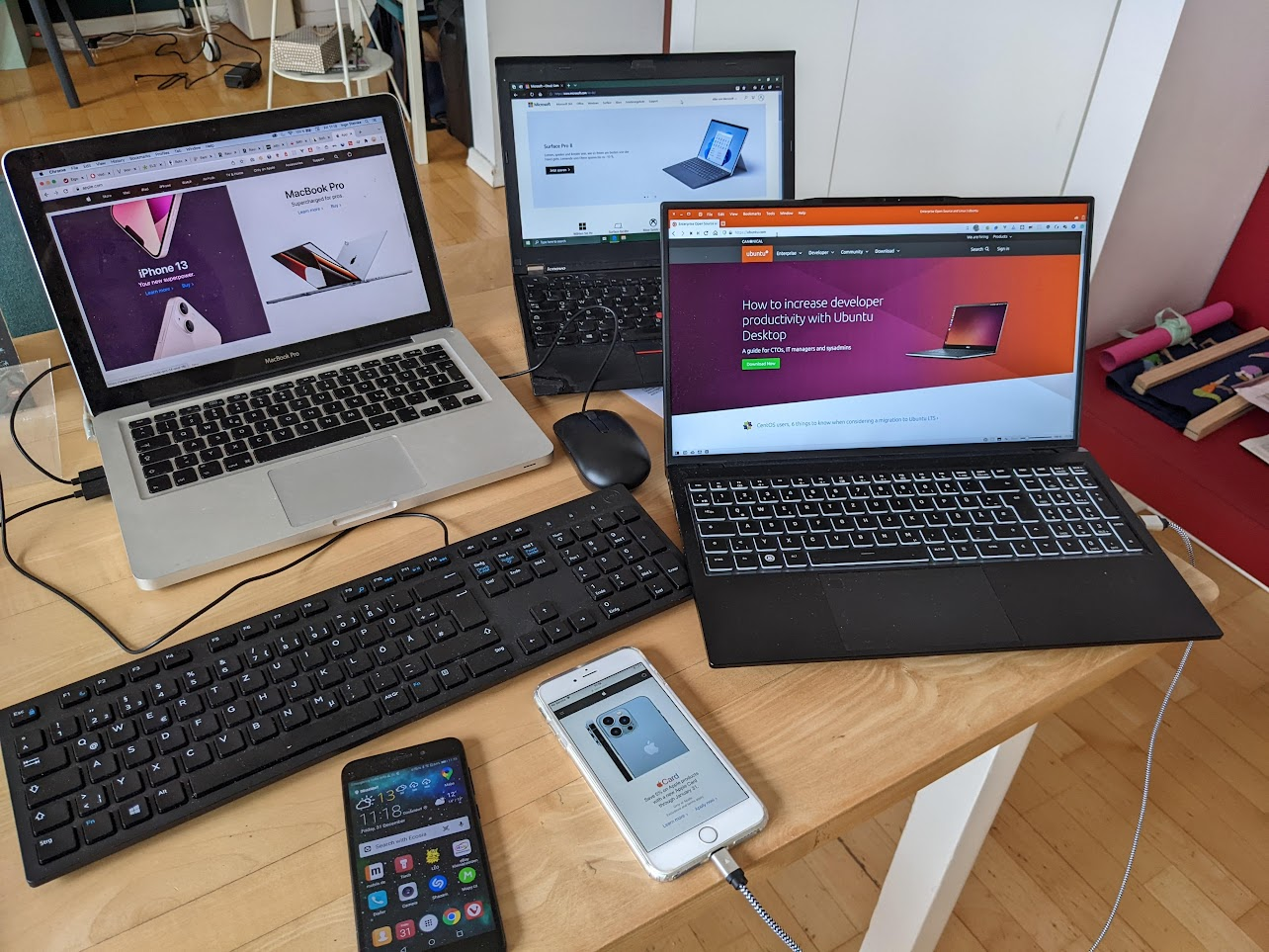 Various computers and phones on a table, as described in the previous paragraph.